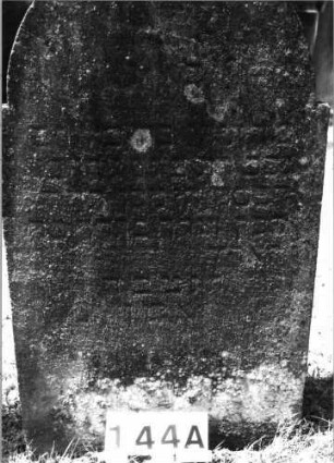 Grabstein 144 (Index: 100085461) Maße HxBxT: 104x60x16 cm Beschreibung: Stele, eingezog. Rundbogenabschl. , Schriftfeld eingetieft mit Maßwerk auf Vordersei: Grabstein 144A