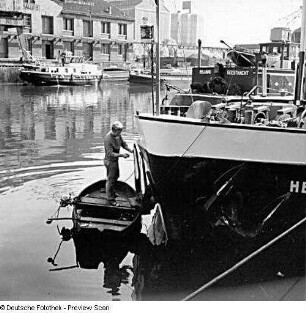 Berlin-Moabit, Turmstraße 57. Westhafen. Hafenbecken. Reparatur an einem Motorschiff von einem Boot aus. Blick gegen Hafengebäude