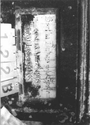 Grabstein 122 (Index: 99800074) Material: Sandstein, Schriftplatten Marmor Zustand: verwittert, Schriftplatte gesprungen Maße HxBxT: 162x56x24 cm Beschreibung: Stele, Mittelerhöhung, Zinnenaufsatz, eingelassene Schriftplatte mit Kleeblattbogenabschluß, getreppter Sockel, im oberen Teil weitere Schriftplatte eingelassen: Grabstein 122B