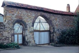 Natursteinhofmauer mit rundbogigem Tor und Personenpforte