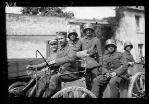Origny (=Origny-Sainte-Benoite, Dep. Aisne, Frankreich): Offiziere mit Stahlhelm und Schirmmütze auf einem Wagenkarren (Nahaufnahme)
