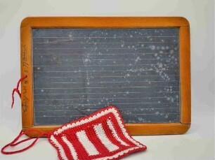Schiefertafel mit rot-weißem Läppchen