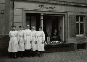 Roßwein, Wohnhaus mit Laden (Friseursalon Wüstling), Kreuzplatz 6, um 1880, Straßenansicht des Ladens mit Chef und Mitarbeiterinnen