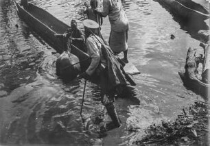 Flussüberquerung : Begleiter der Expedition während der Vorbereitung für die Flussüberquerung mit Booten. Einer der Begleiter hält ein Maultier am Halfter