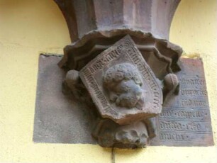Stadtkirche-Kirchturm von Osten mit Chorerker (Heiliggeistkapelle 1419) im ersten Obergeschoß-Konsolenbasis mit Textschild (14xx-beschädigt) und Kopf in Hochrelief sowie Textinschrift rechts-060420155