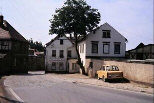 Dorfstraße, lange Mauer, hinten Gaststätte "Zur Bleibe"