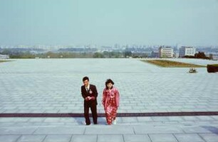 Paar vor dem Großmonument Mansudae mit der Statue von Kim Il-sung