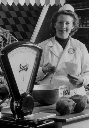 Pro Verkäuferin : Eine Verkäuferin der "Pro"-Lebensmittelkette bei der Arbeit. Sie steht am Wurststand. Aufgenommen 1950