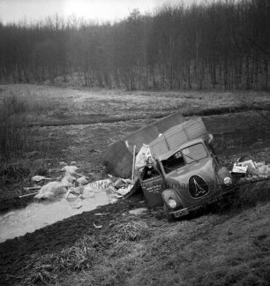 A1: Verkehrsunfall: Lastzug stürzt Böschung hinab: Unfall-Lastzug bei Graben mit Wasser, Ladung Herde, Kartons, Rohre, Füllmaterial herausgefallen: hinten Bachlauf, Wiesen, Wald