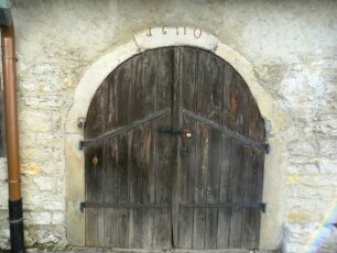 Kirchhof im Nordnordwesten-Steingaden (innenseitig an die Kirchhofmauer angebaut)-Eingang mit Jahresazhel 1611 im Gewändeschlußstein