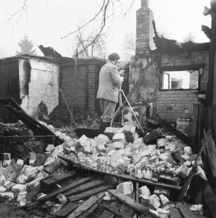 Brand: Sieker Landstraße: Behelfsheim: Brandruine: Innenraum: darin Mauerwerk und verbrannte Gegenstände: in der Mitte Brandsachverständiger beim Fotografieren: hinten Bäume