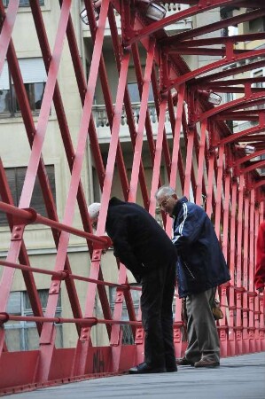 Girona - Fußgängerbrücke von Eiffel : Zwei Männer stehen auf der Fußgängerbrücke von Gustave Eiffel, aufgenommen am 16. April 2012 in der Altstadt von Girona