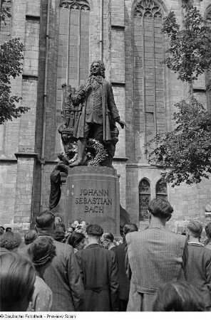 Junger Mann auf dem Bach-Denkmal einen Ehrenkranz niederlegend
