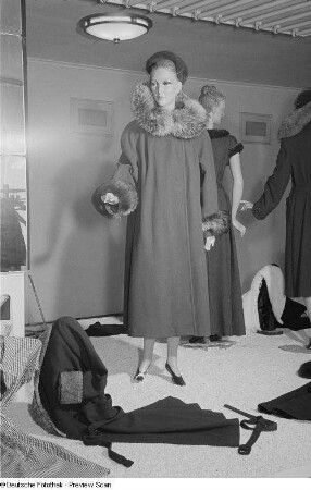 Mantel mit Pelzkragen und weitere Textilien an Schaufensterpuppen auf der Leipziger Herbstmesse 1954