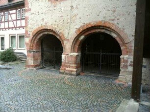 Stadtbild-Romanisches Steinhaus (1187-Vogtei 1984-renoviert)- Ansicht querab über Hofseite mit Arkaden der Erdgeschoßhalle (abgetreppte Steinbögen auf Kämpfern)