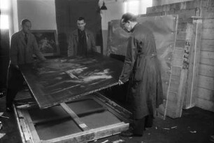 Mitarbeiter des Collecting Points Marburg beim Auspacken eines Gemäldes (Jaocob Jordaens, Satyr in einer Bauernfamilie) im Hessischen Staatsarchiv Marburg 1945