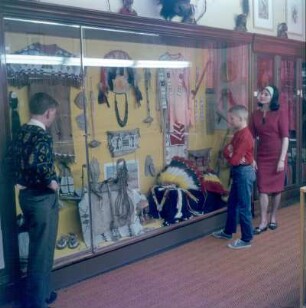 Bamberg. Karl-May-Museum. Schauwand mit Indianer-Federkopfschmuck, Frauensattel, Lasso und Peitsche
