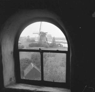 Blick durch das geschlossene Fenster einer Windmühle gegen Holländerwindmühle