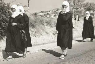 Ost-Rhodopen, Bulgarien. Balkanhalbinsel. Mohammedanische Frauen in Tracht, auf einer Landstraße laufend