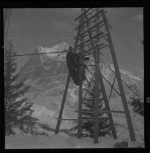 Handwerker auf einem Strommast in den Berner Alpen