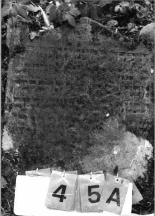 Grabstein 45 (Index: 99790656) Zustand: sehr stark verwittert Maße HxBxT: 64x48xo.A. cm Besonderheit: Kindergrab; - Lesung sehr unsicher: Grabstein 45A