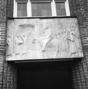 Evangelische Auferstehungskirche: Alte Landstraße: Relief "Jesus' Einzug in Jerusalem" des Bildhauers Siegfried Assmann über Eingang: darüber Fenster