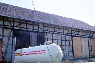 große Fachwerkscheune mit mehreren Holztoren, Flüssiggastank