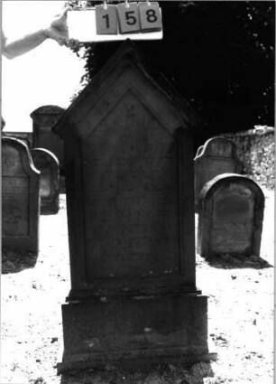 Grabstein 158 (Index: 99798020) Material: Sandstein, rot Zustand: gut Maße HxBxT: 128x62x18 cm Beschreibung: Stele, giebelartiger Abschluß mit Verdachung, getreppter Sockel: Grabstein 158