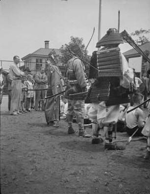Traditionelles japanisches Bogenschießen in der deutschen Schule zu Ōmori : Tokio-Ōmori (heute Tokio-Ōta). Traditionelles japanisches Bogenschießen in der deutschen Schule zu Ōmori. Stehende Bogenschützen in traditioneller Bekleidung