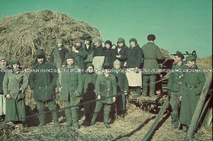 Wehrmachtssoldaten mit ukrainischen Bauern vor Heuhaufen