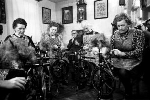 Frauen beim Flachsspinnen in Wohnstube