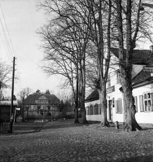 Gasthof "Burgkrug von 1695": Am Mühltenteich: Kopfsteinpflaster: rechts vor Gebäude Baumreihe: links Strommast und Bushaltestelle: hinten links Trittauer Wassermühle