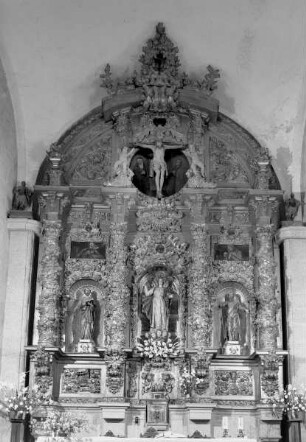 Hochaltar mit Madonna flankiert von zwei Heiligen, darüber im Gesprenge der Gekreuzigte
