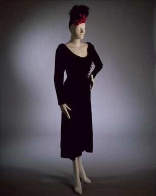 Schwarzes Samtkleid von Chanel und schwarze Kappe mit Pelzbesatz und Stoffrosen (Archivtitel)