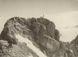 Wanderer besteigen den Ostgipfel der Zugspitze. In der Bildmitte das Gipfelkreuz