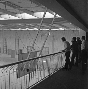Bargteheide: Kreisgymnasium II [später Gymnasium Eckhorst]: Eckhorst: Sporthalle: vor Fertigstellung: Innenaufnahme: Besichtigung durch Kreispräsident Hubert Priemel, Landrat Hans-Henning Becker-Birck, Fachleute beim Blick von Galerie in Halle