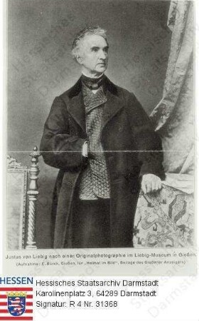 Liebig, Justus Freiherr v., Prof. Dr. med., Dr. phil. (1803-1873) / Porträt in Raumkulisse, stehend, linksblickend, Kniestück