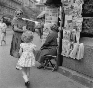Budapest. Zwei Frauen vor einem Zeitungskiosk, ein kleines Mädchen geht daran vorbei