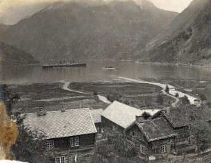Merok. Ortsteilansicht. Blick über die Bucht zum Hochseepassagierdampfer "Victoria Luise"