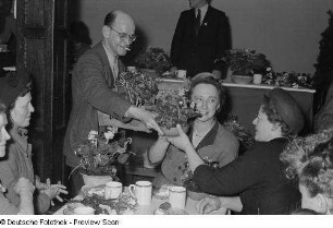 Übergabe von Blumengeschenken auf einer Veranstaltung zum Internationalen Frauentag