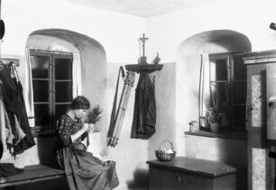 Schönfeld Interieur. Martha Quarck in der Bauernstube stopfend, in der Zimmerecke hängen wohl Feldstaffelei und Jacke des Malers Karl Quarck
