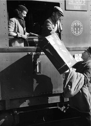 Berlin: Anhalter Bahnhof; Fräulein Böhnstedt und Herr Schlüter im Wagen; Träger reicht [Koffer] herauf