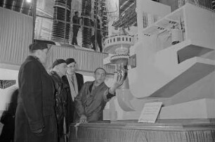 Messebesucher beim Betrachten einer technischen Anlage in der Ausstellungshalle der Sowjetunion
