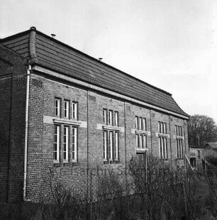 Turnhalle Woldenhorn-Schule: Sonderschule des Kreises Stormarn für geistig behinderte Kinder: Ecke Reeshoop / Schulstraße: ehemalige Turnhalle der Grundschule Am Schloss nach Modernisierung: Außenaufnahme: vorne Maschendrahtzaun