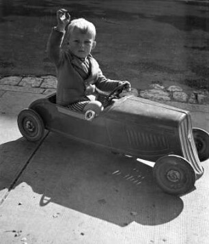Kinderbilder. Kleiner Junge in einem Spielzeugauto in Bayreuth