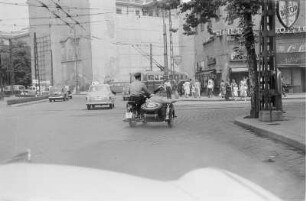 Stadtbild mit Straßenverkehr und Passanten