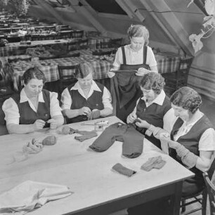 Werkfrauen beim Flicken von Kleidungsstücken