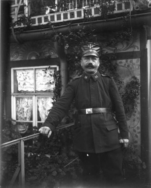 1. Weltkrieg. Portrait eines Soldaten, vor einem Haus stehend