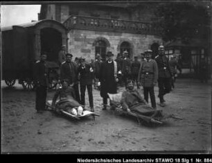 Ankunft von Verwundeten auf dem Wolfenbütteler Bahnhof Enthält: Zwei Verwundete auf Bahren, Transportwagen, Helfer [vgl. 18 Slg 2 Nr. 56]