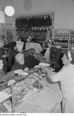 Verkäuferinnen bedienen Kunden einer Fleisch- und Wursttheke